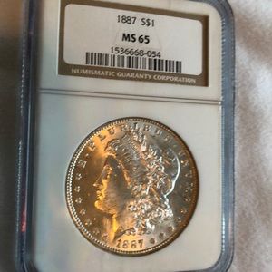 1887 Morgan silver dollar MS65 by NGC.